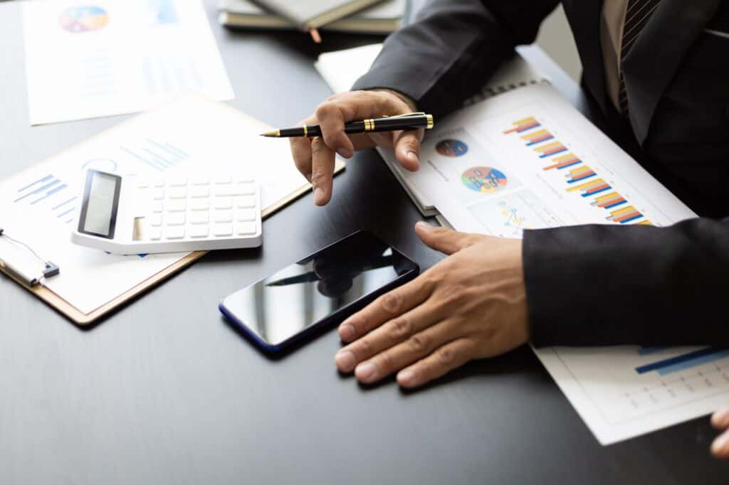 Businessman in the office financial analysis and bookkeeping using smartphone.