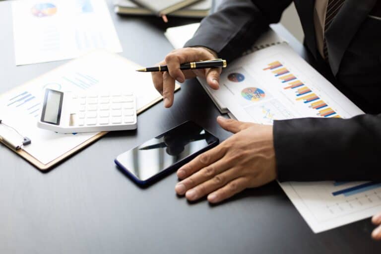 Businessman in the office financial analysis and bookkeeping using smartphone.