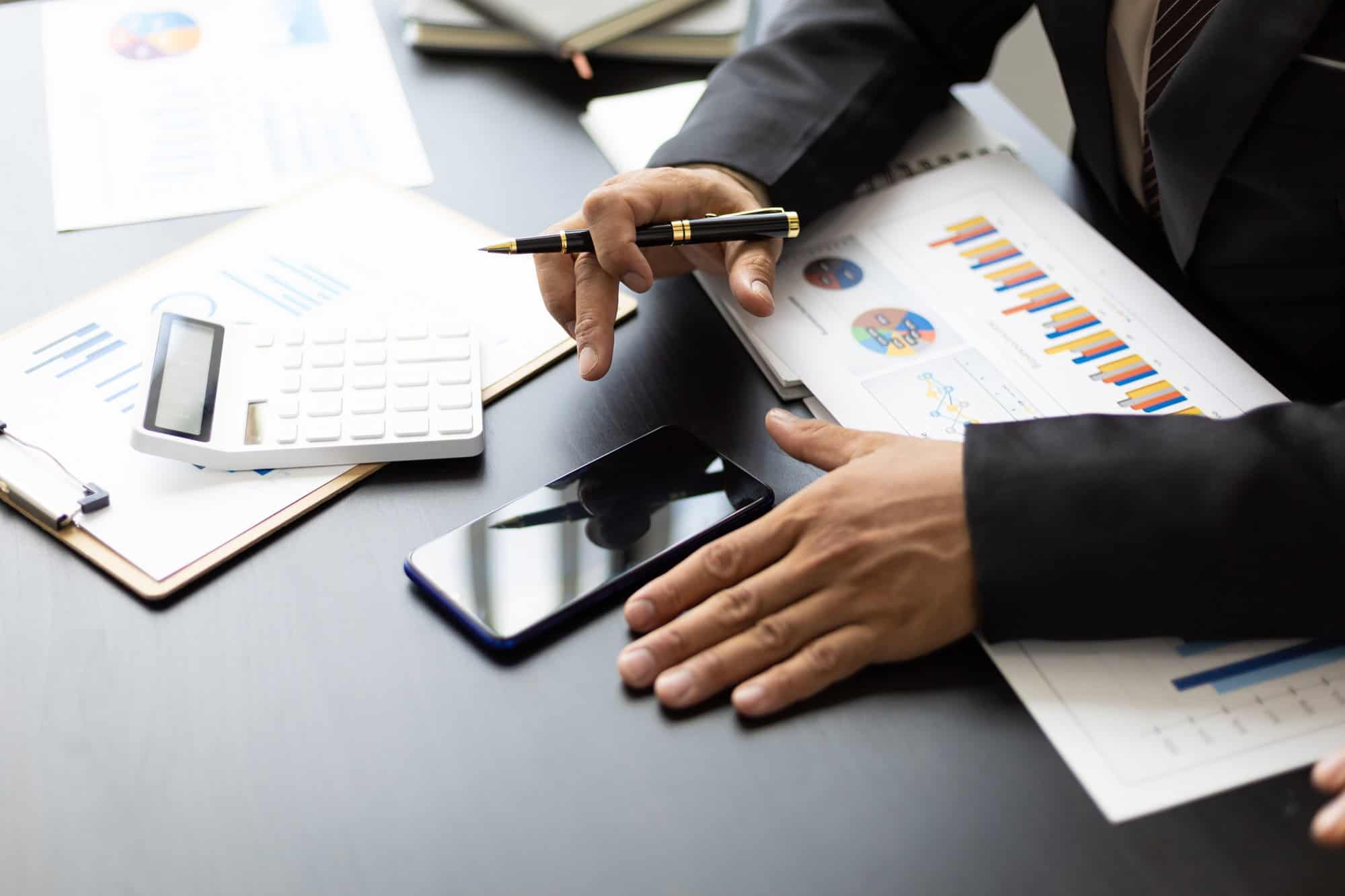 Businessman in the office financial analysis and bookkeeping using smartphone.