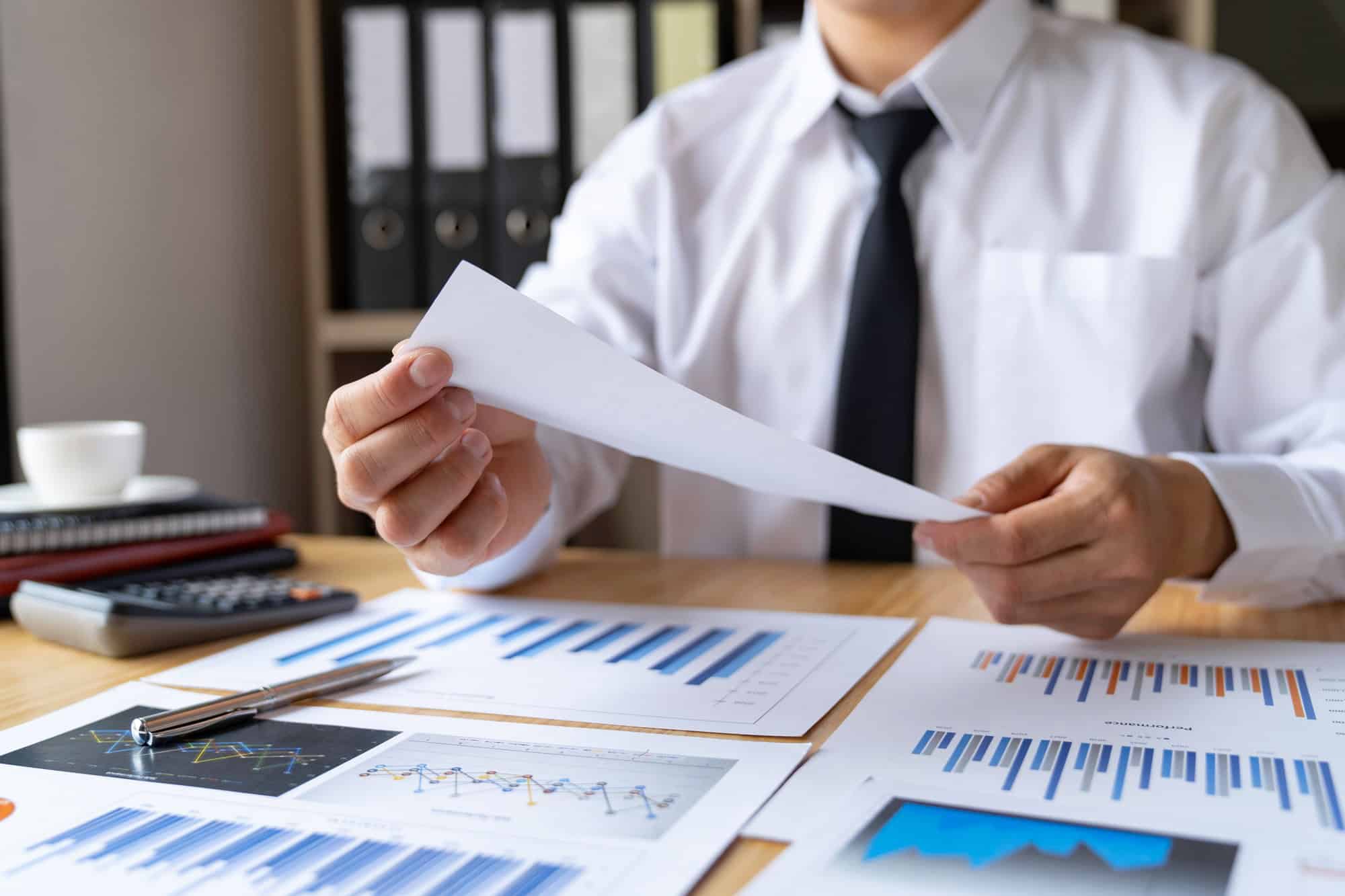Close-up of businessman's hands collecting bills for tax refund and tax savings, finance banking and
